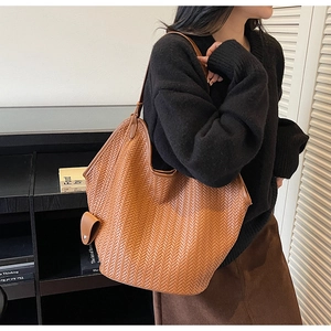 Gros plan détaillé de la texture tissée du sac cabas marron caramel à grande capacité