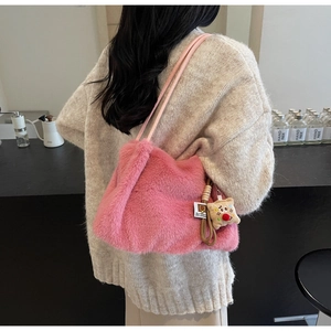 Dettaglio della borsa a spalla in peluche rosa con morbida pelliccia e ciondolo