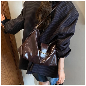 Détail d'un sac à bandoulière en cuir ciré marron avec plis vintage et boucle en métal doré