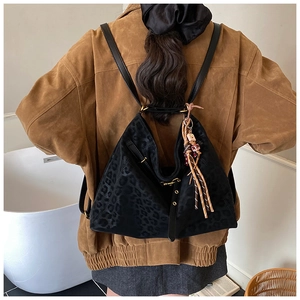 Detail of leopard print tote backpack with tassel pendant on soft matte texture fabric
