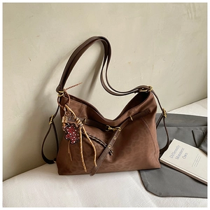 Detail of vintage brown leopard print tote bag with heart bear charm and suede texture