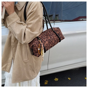 Detail of vintage leopard print boston shoulder bag with colorful wooden beaded pendant
