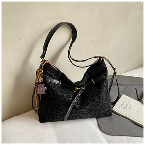 Close-up of leopard print tote bag with faux fur texture and a cute bear charm accessory