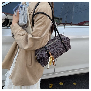 Detail of vintage leopard print cylinder bag with stylish wooden bead pendant decoration