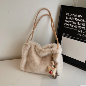 Dettaglio della borsa in peluche beige con sottili spalline e ciondolo a forma di toast