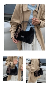 Detail view of black faux fur plush handbag with adjustable strap and decorative charm