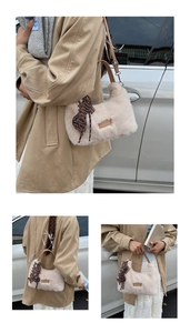 Detail of plush shoulder bag in beige featuring leather straps and side letter charm