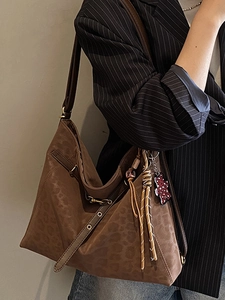 Retro leopard print tote bag with brown texture and bear pendant worn by a model