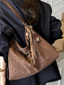 Brown leopard print tote bag with plush texture and stylish bear charm on leather strap