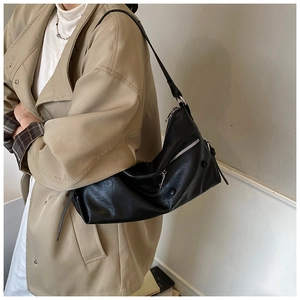 Detail der schwarzen Leder-Motorradtasche mit silbernen Nieten und Reißverschlüssen