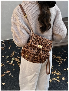 Detail of leopard print quilted backpack with golden twist lock and chain strap for women