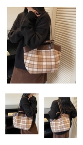 Detail showing vintage plaid tote bag with brown leather trim worn by a model in interior