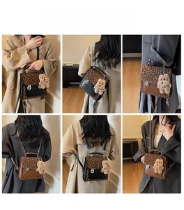 Detail of leopard print backpack with silver twist lock and plush bear charm