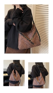 Detail of leopard print tote bag with black leather straps and metal hardware