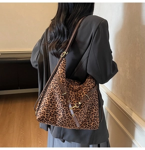Detail of leopard print faux suede tote bag featuring adjustable dark brown leather strap