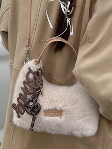 Beige faux fur handbag with brown leather handles and Bony charm on khaki coat