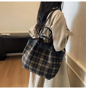 Detailed view of the large capacity plaid tote bag with faux leather handles on a model