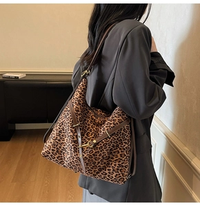 Close-up of leopard print hobo bag with brown leather strap and gold buckle detail