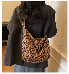 Large leopard print canvas tote bag shown worn over the shoulder with an oversized blazer