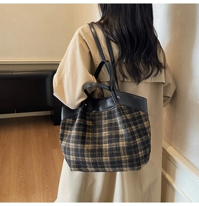 Back view of model wearing a vintage plaid tote bag with black leather straps