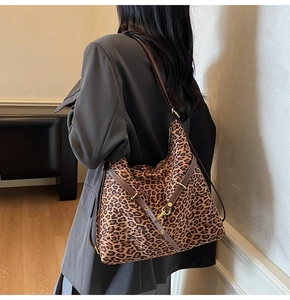 Detailed back view of model wearing a leopard print hobo bag with brown leather trim