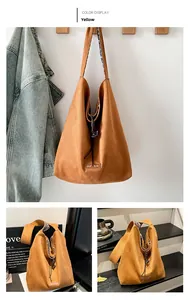 Detail of yellow suede tote bag featuring floral pattern strap lining and wide shoulder strap