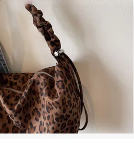 Detail of leopard print tote bag with ruffled shoulder strap and silver metal buckle