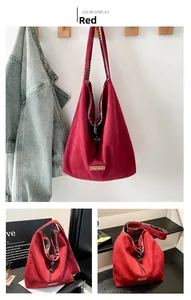 Detail view of red suede tote bag with plaid lining and drawstring closure design