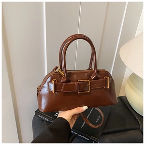 Detail view of the deep brown vintage Boston bag with glossy leather and metal buckle strap