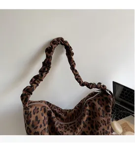 Detail of leopard print tote bag featuring a cloud-style ruched handle and smooth zipper