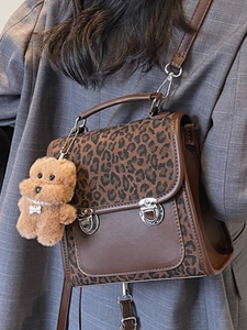 Fashionable leopard print shoulder bag with brown leather trim and plush bear charm
