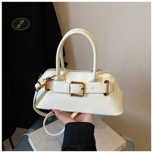 Detail of white leather shoulder bag featuring vintage gold buckle and round handles