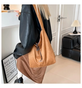 Brown faux suede tote bag with drawstring detail and brand label shown on model
