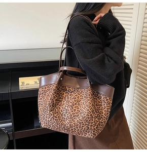 Detail of leopard print tote bag with brown leather handles and large capacity design