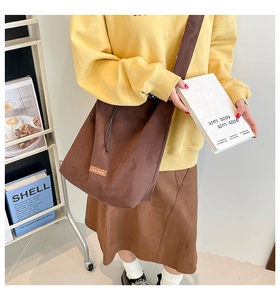 Detail showing the brown suede crossbody bag with our fave label and large capacity