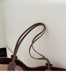 Detail of brown crocodile pattern tote bag with reinforced stitching on dual slim straps
