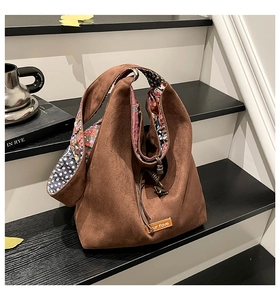 Detailed macro view of the brown suede hobo bag with colorful floral print lining and strap