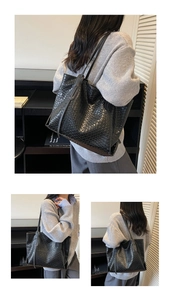 Detailed view of black woven leather tote bag texture and long shoulder strap