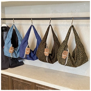 Detail view of retro tote bags in denim and leopard print with cute bear charms