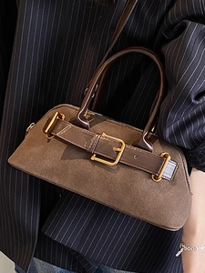 Brown vintage suede tote bag with dark leather straps and gold buckle worn with a blazer
