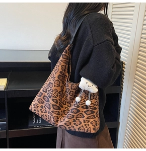Leopard-Print-Einkaufstasche mit Wolken-Anhänger über der Schulter für einen Herbst-Look