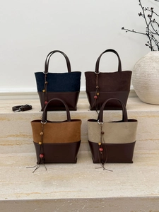 Detail view of four-color patchwork tote bags with suede texture and metal ring buckles
