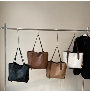 Close-up of four tote bags in black, brown, and cream with woven textures on display