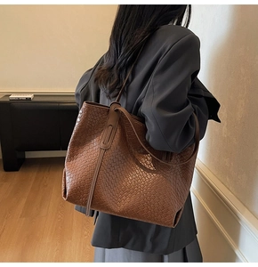 Detail of dark brown woven leather tote bag texture and large capacity structure