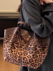 Classic leopard print tote bag with brown leather trim shown on a female model shoulder