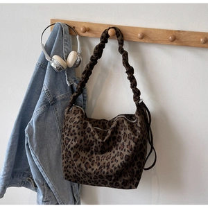 Macro shot of stylish leopard print tote bag featuring a trendy pleated scrunchie shoulder strap