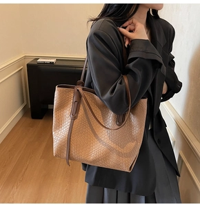 Macro detail of the woven texture and contrast brown leather straps on khaki tote bag
