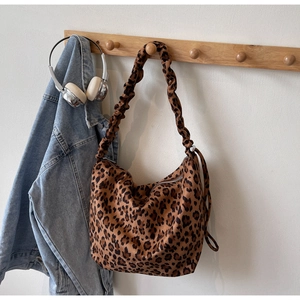 Detail of leopard print tote bag with ruched shoulder strap and zipper closure