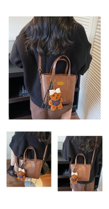 Detailed view of brown leather bucket bag with cute teddy bear charm and metal buckle