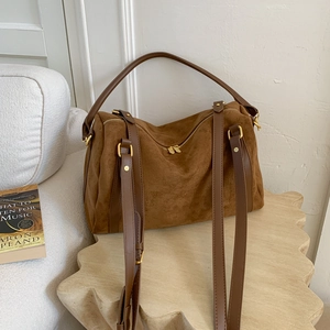 Vue détaillée d'un sac Boston en daim marron avec fermetures éclair dorées